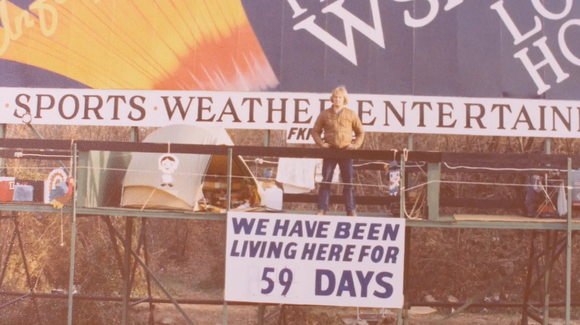 The WSAN billboard above Route 22, with a sign reading “We have been living here for 59 days”