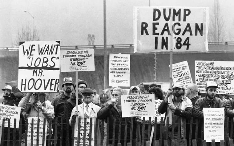 Protesters holding signs reading “Dump Reagan in 84” and “We want jobs”