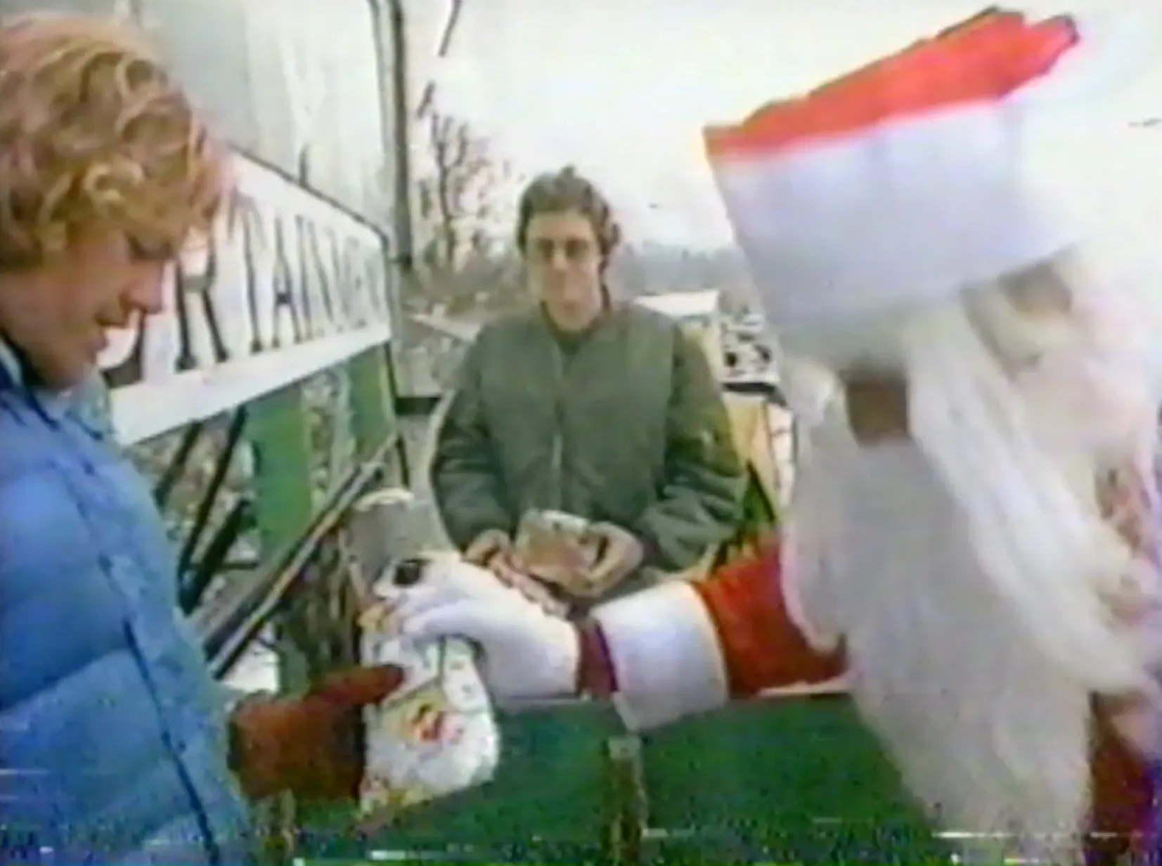 Santa Claus handing a gift up to the contestants